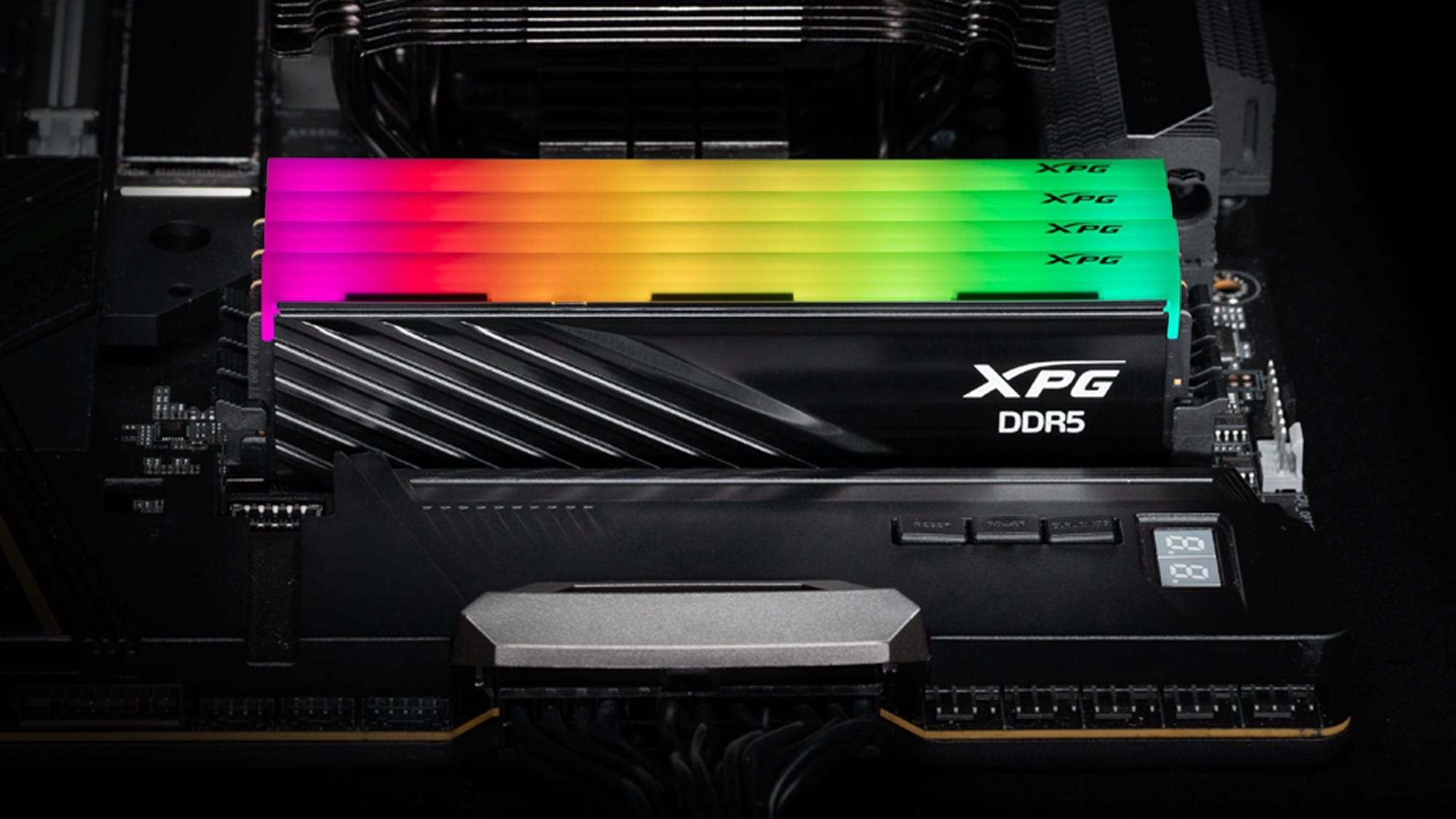 An image of four XPG DDR5 memory modules in a motherboard. They all are lit with colourful RGB LEDs.