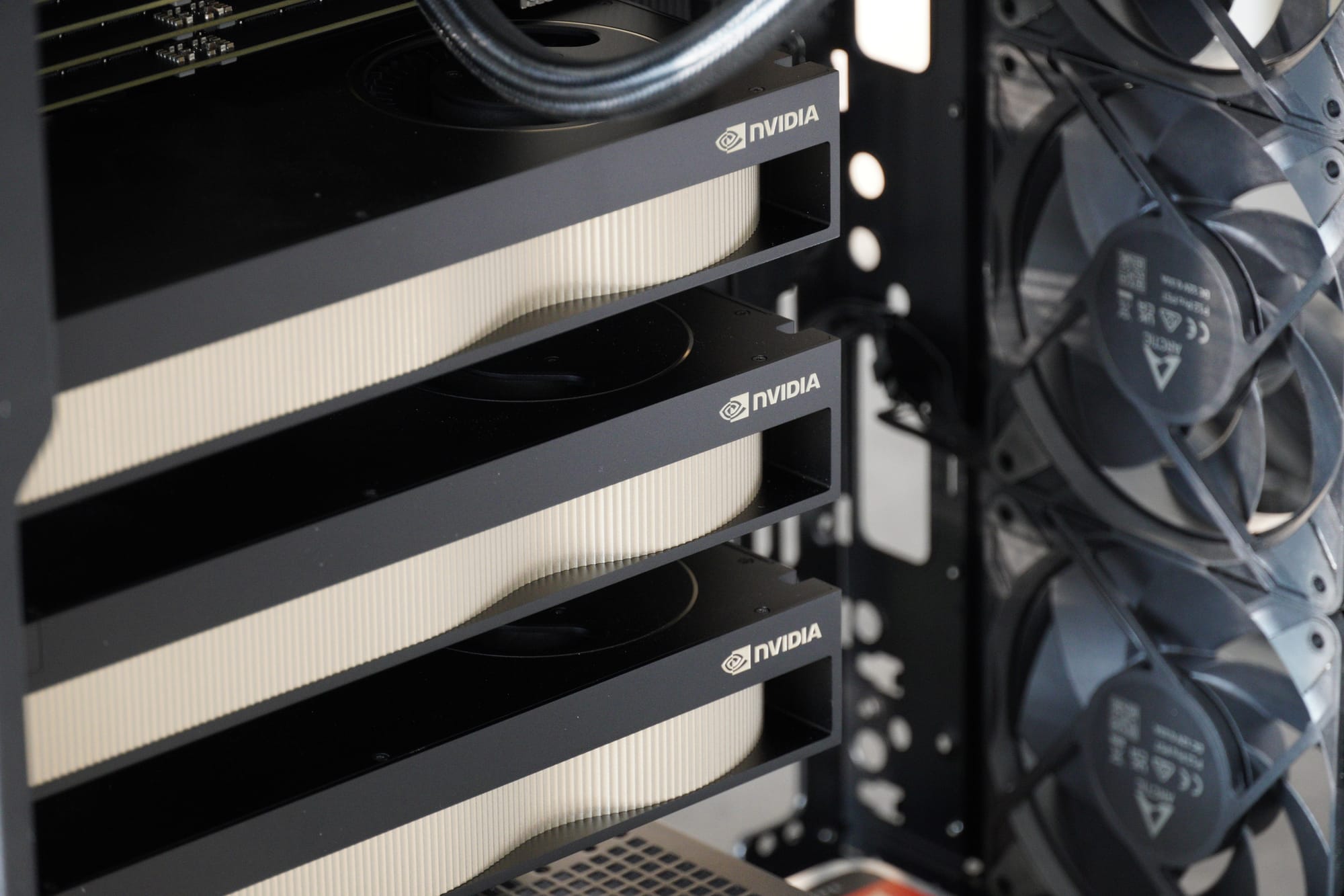 The fully assembled workstation — three RTX PRO 6000 cards, AIO radiator mounted, cable management complete