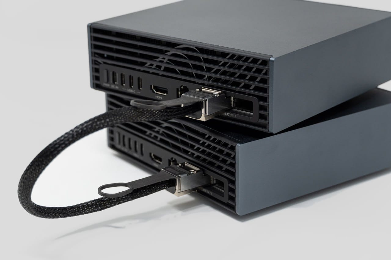 Rear three-quarter view of two stacked GIGABYTE AI TOP ATOM systems joined by one direct-attach cable