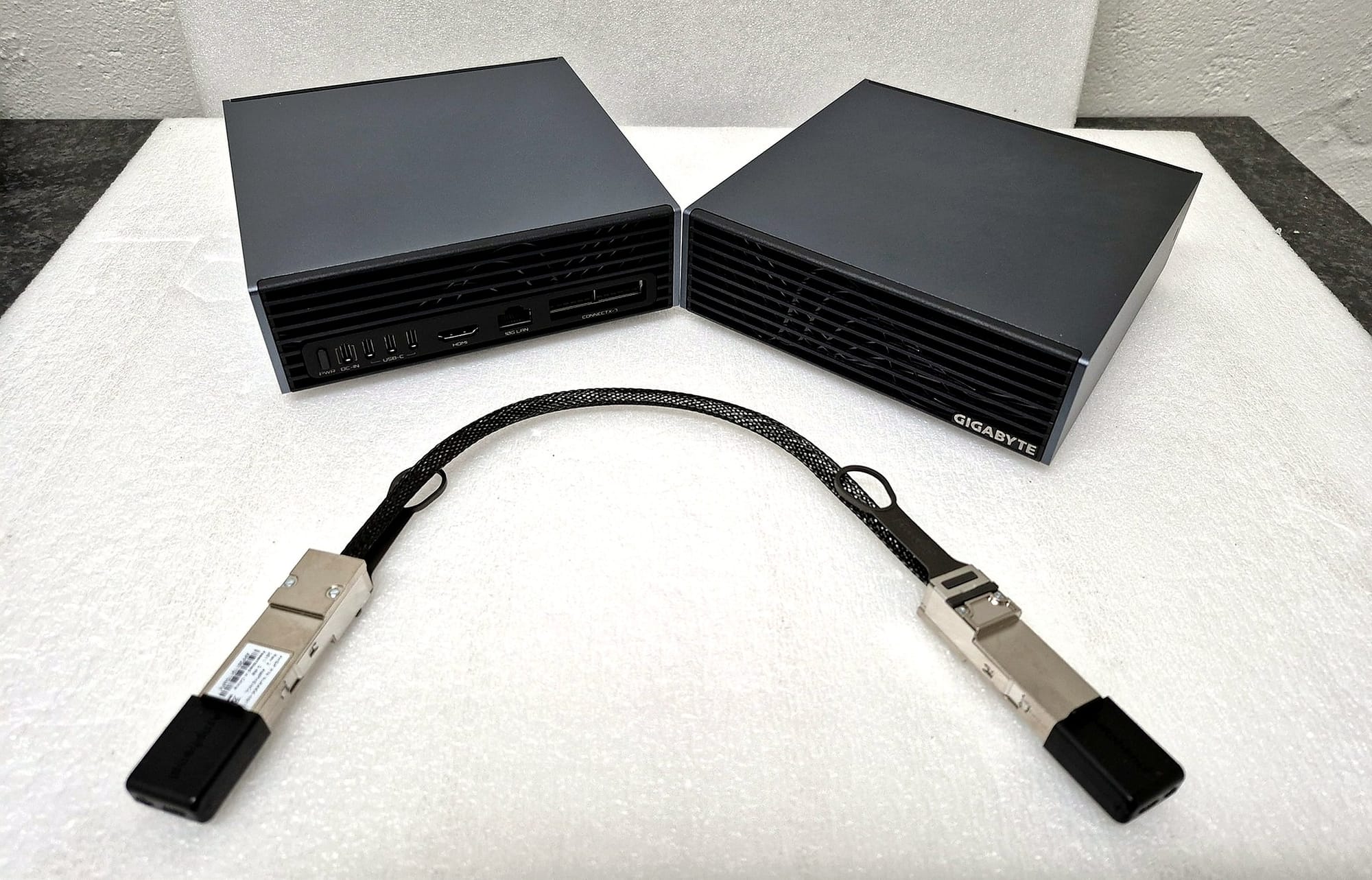 Two GIGABYTE AI TOP ATOM systems with the full QSFP112 direct-attach cable used by Wootware