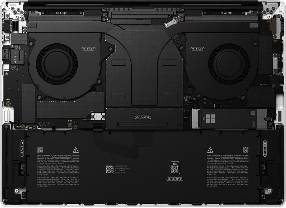 Inside the Surface Laptop Ultra with the base removed: twin cooling fans across the top, a covered 1TB SSD, and a battery filling the lower half